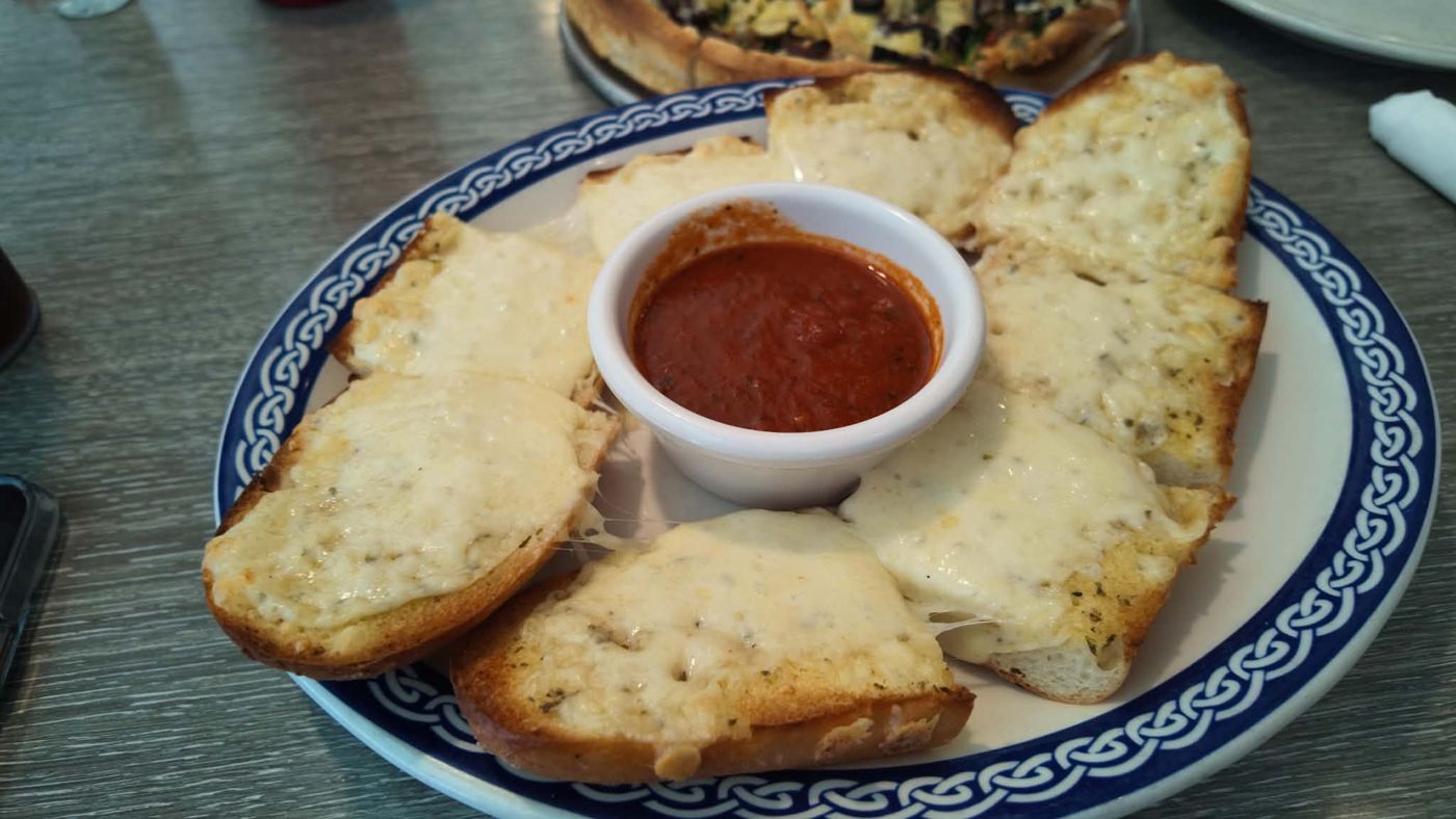 Athens Pizza cheesy garlic bread with melted mozzarella and a side of red sauce